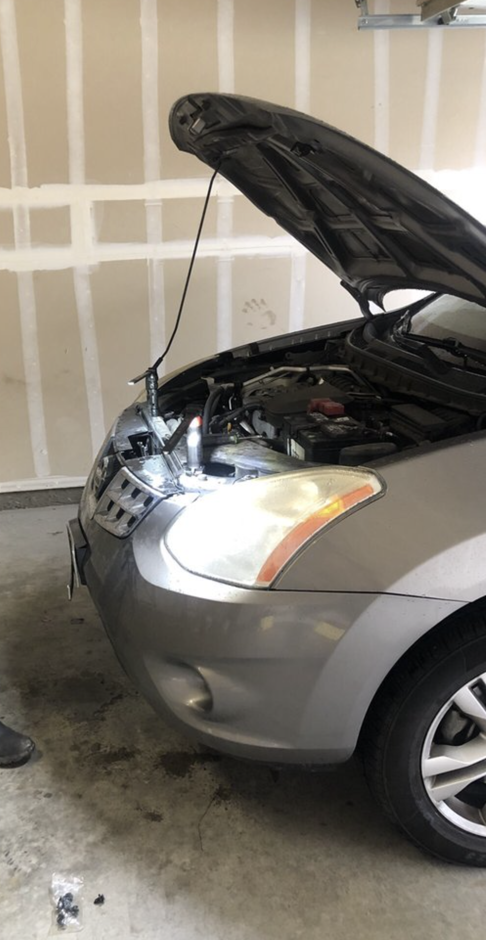 Mobile mechanic checking a car with the hood open